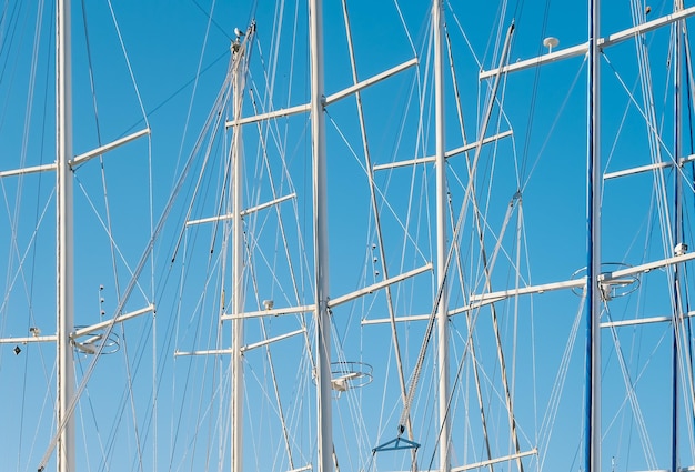 Siluetas de yates en el puerto deportivo con el telón de fondo de un cielo azul claro una idea para un fondo o noticias sobre navegación a vela