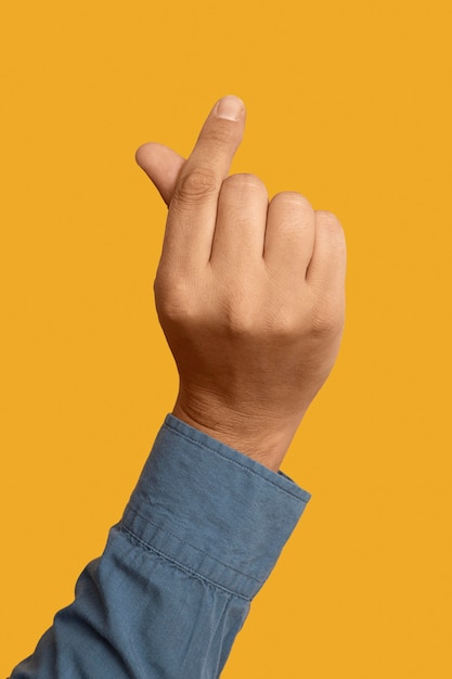 Foto gratuita símbolo de lenguaje de señas aislado en amarillo