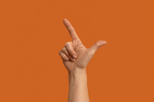 Foto gratuita símbolo de lenguaje de señas aislado en naranja