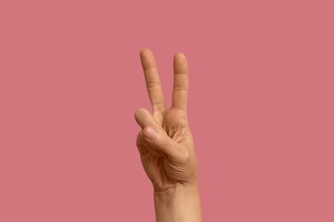 Foto gratis símbolo de lenguaje de señas aislado en rosa
