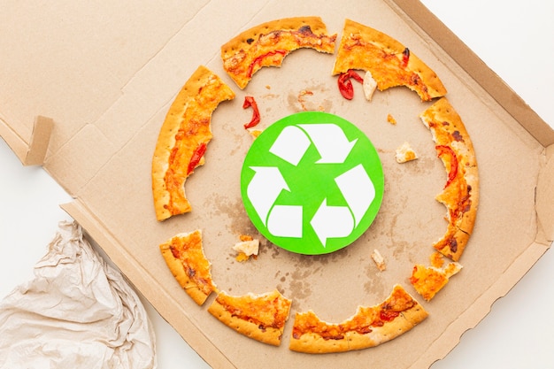 Foto gratuita símbolo de reciclaje y comida de pizza sobrante