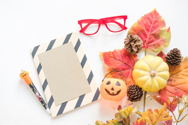 Símbolos de Halloween cerca de artículos de papelería y gafas