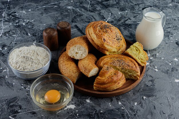 Simit de bagel turco picado con huevo de gallina crudo y una jarra de vidrio de leche.