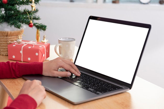 Simulacros de computadora portátil con pantalla blanca en la mesa de oficina