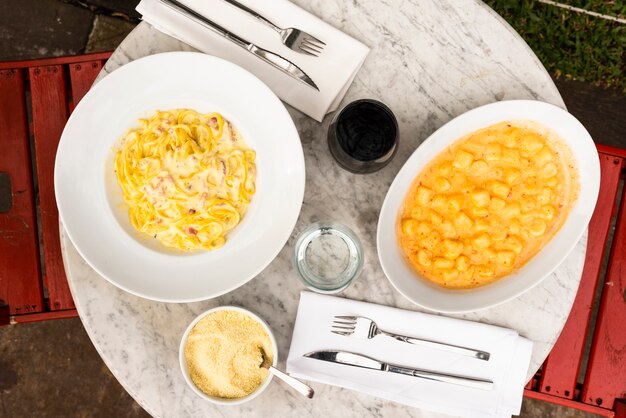 Sirva platos de pasta italiana en una mesa de mármol en el restaurante.