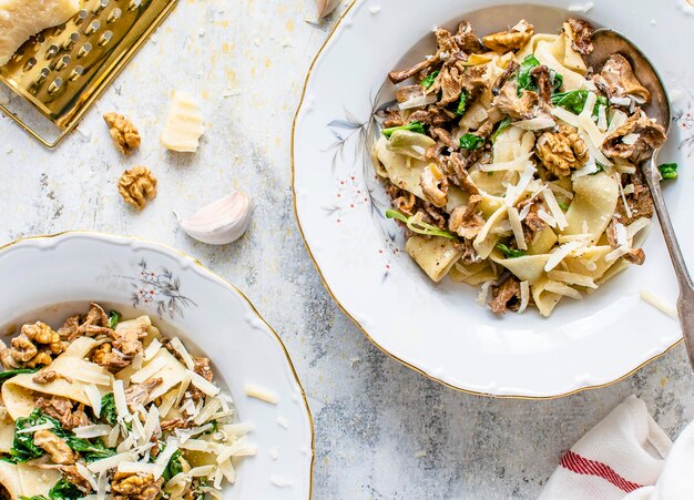 Sirviendo de pasta pappardelle casera con champiñones y queso parmesano