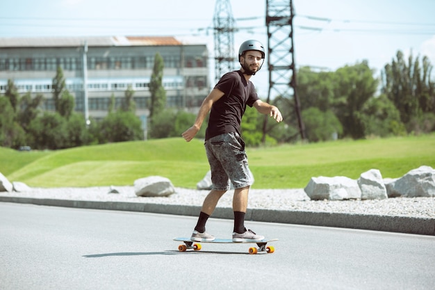 Foto gratuita skater haciendo un truco en la calle de la ciudad en un día soleado.