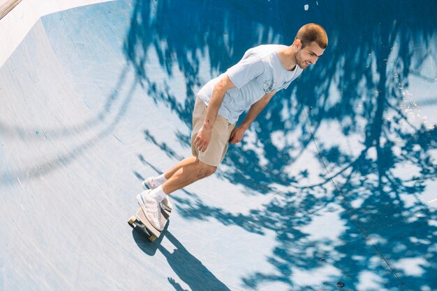 Skater sonriendo y montando en rampa