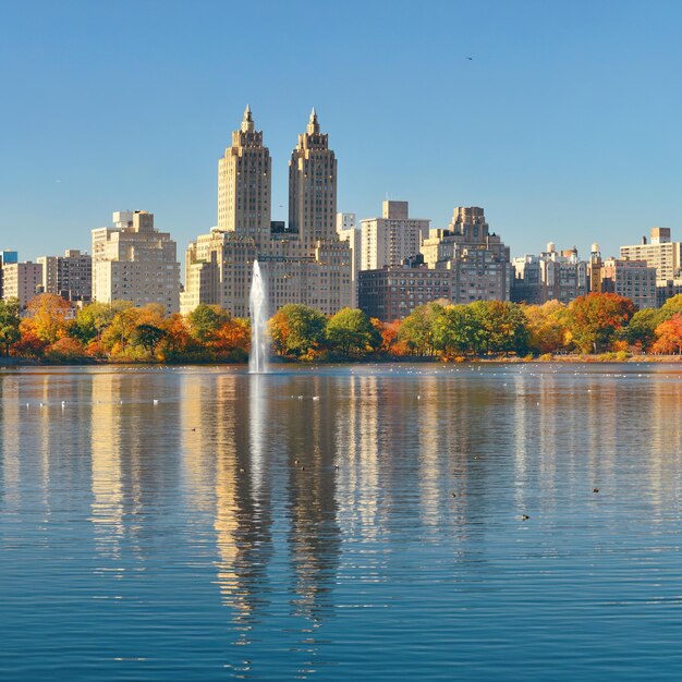 Skyline con rascacielos de apartamentos sobre el lago con una fuente en Central Park en el centro de Manhattan en la ciudad de Nueva York