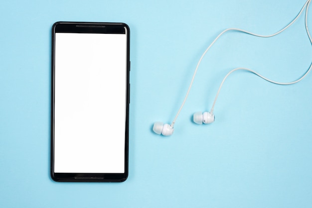 Smartphone con auriculares sobre fondo azul