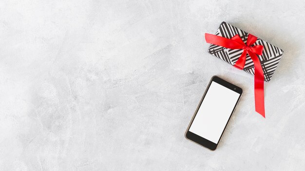 Smartphone con caja de regalo en mesa