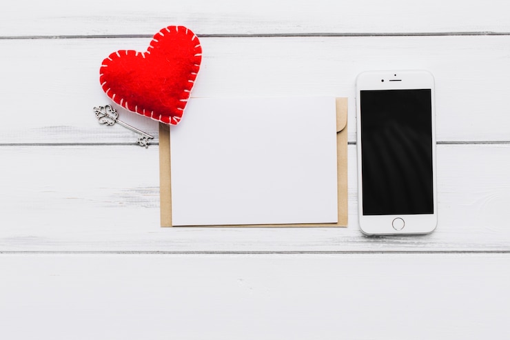 Foto gratuito smartphone cerca de papel y corazón