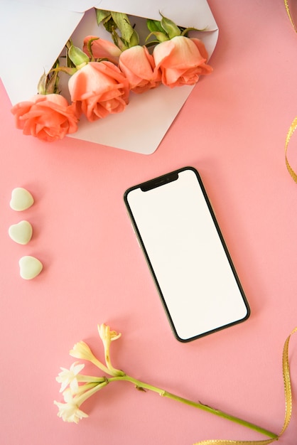 Smartphone con flores rosas en sobre