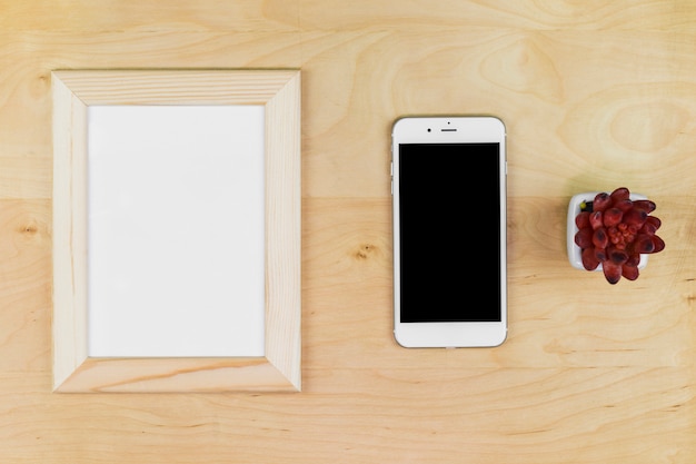 Smartphone con marco en blanco en la mesa