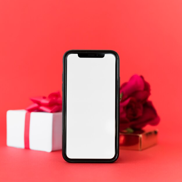 Smartphone con pantalla en blanco y regalo.