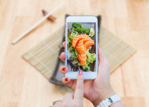 Smartphone tomando salmón Sashimi