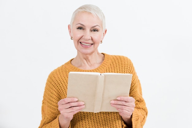 Smiley anciana posando mientras sostiene el libro