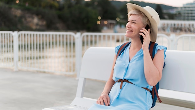 Foto gratuita smiley anciana turista hablando por teléfono