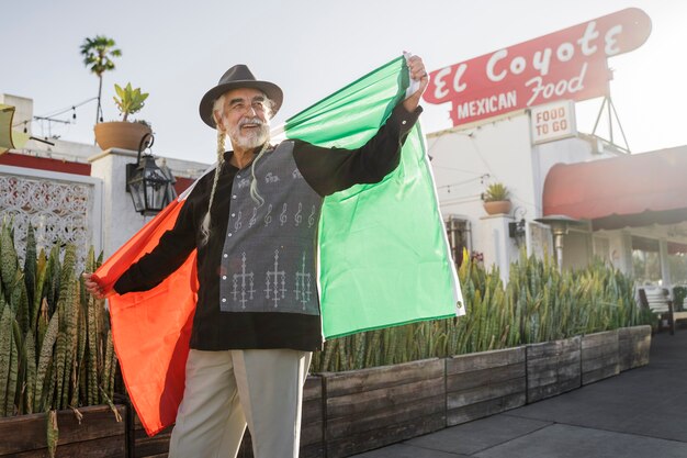 Foto gratuita smiley anciano con bandera mexicana tiro medio