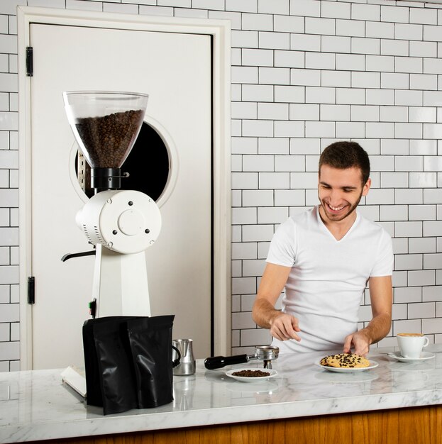 Smiley barista detrás del mostrador en la cafetería.