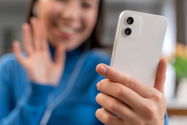 Smiley borrosa mujer sosteniendo teléfono inteligente