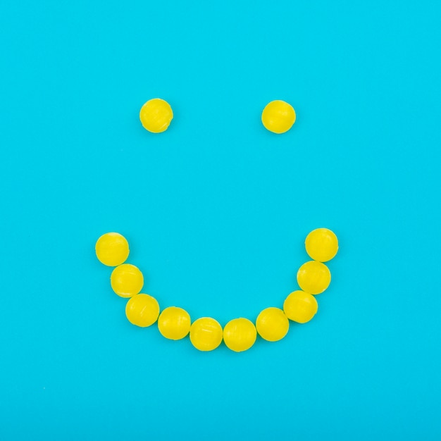 Foto gratuita smiley caramelos de gelatina en mesa azul