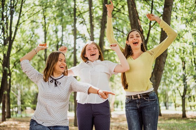 Smiley y chicas juguetonas en el parque juntas