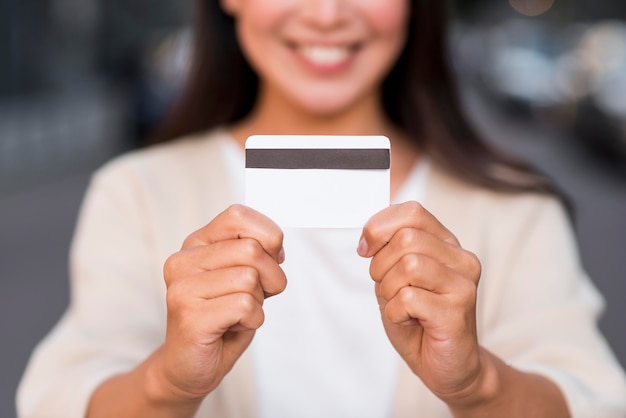 Foto gratuita smiley defocused mujer sosteniendo tarjeta de crédito