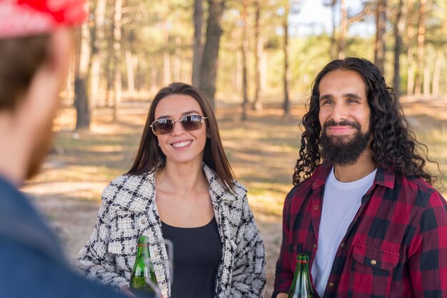 Smiley hombre y mujer conversando con un amigo al aire libre