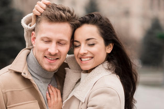 Smiley hombre y mujer posando al aire libre