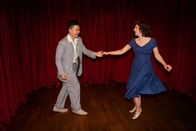 Smiley hombre y mujer swing bailando tiro completo