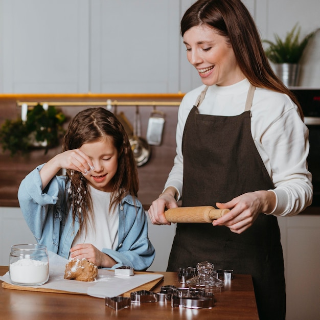 Smiley madre e hija cocinando en la cocina