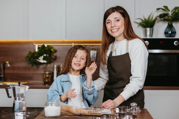 Smiley madre e hija cocinando juntos en la cocina