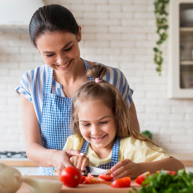 Smiley madre e hija cocinando