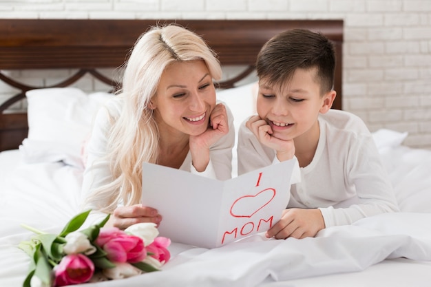 Foto gratuita smiley madre e hijo en la cama