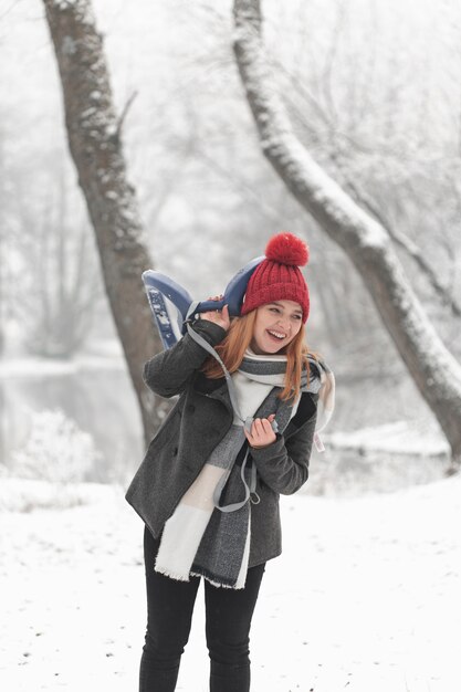 Smiley mujer y trineo paisaje invernal