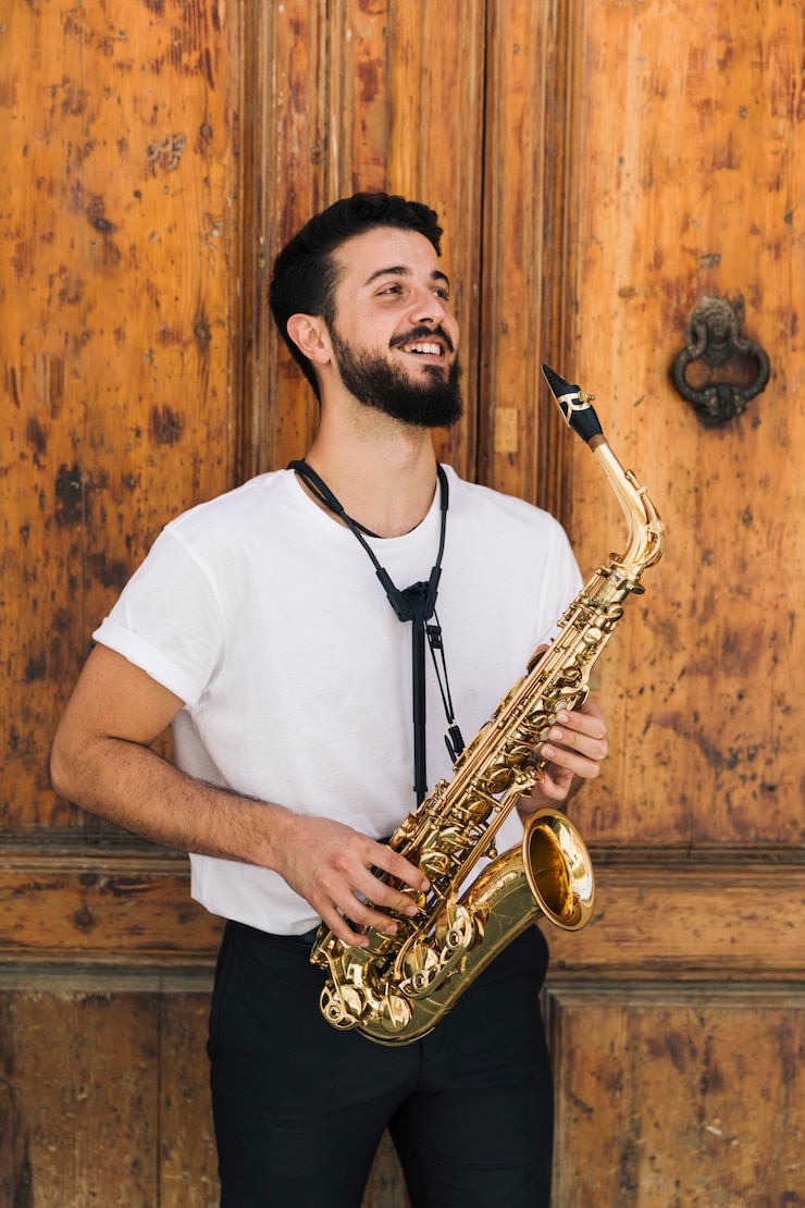Foto gratuito smiley músico con saxo mirando a otro lado