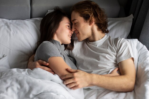 Smiley pareja abrazados en la cama