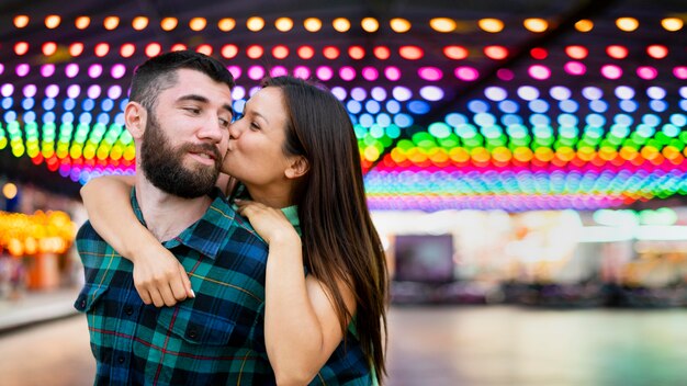 Smiley pareja besándose en el parque de atracciones