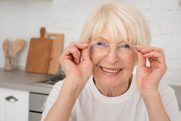 Foto gratuita smiley senior sosteniendo un anteojos