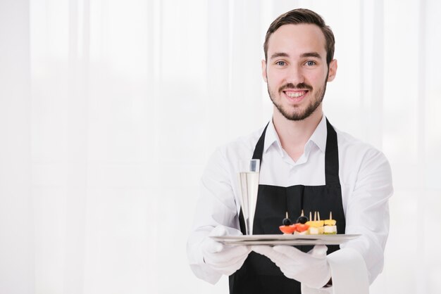 Smiley sommelier mostrando bandeja con espacio de copia