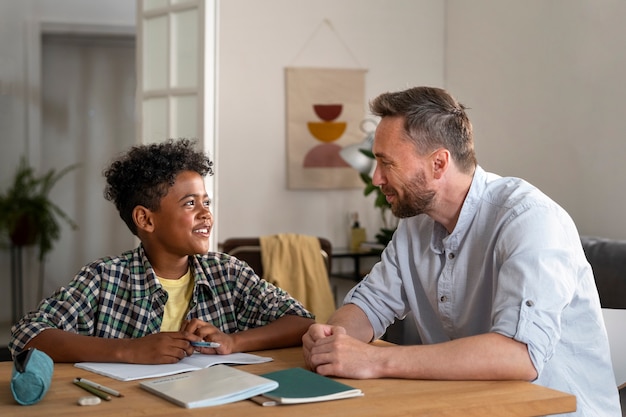 Foto gratuita smiley de tiro medio padre e hijo en casa