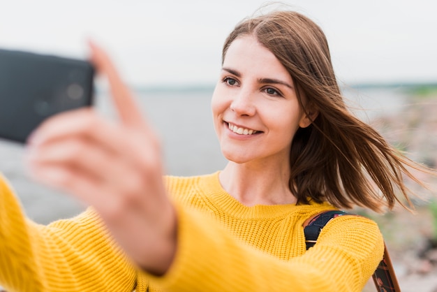 Foto gratuita smiley viajero solo tomando un selfie