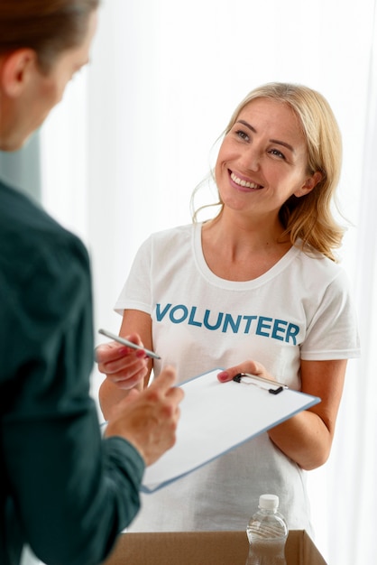 Smiley voluntario ayudando a la persona necesitada