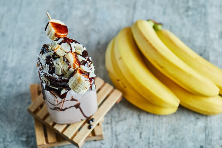 Foto gratuito smoothie de chocolate con jarabe de choco y rama de plátano