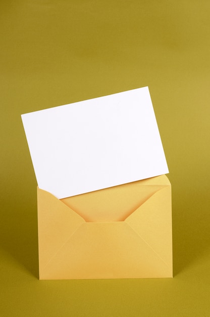 Sobre metálico dorado con tarjeta de mensaje en blanco o invitación.