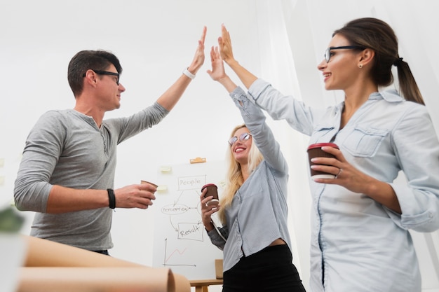 Socios comerciales felices levantando las manos