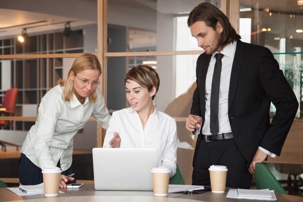 Socios comerciales que negocian estrategias usando una computadora portátil.