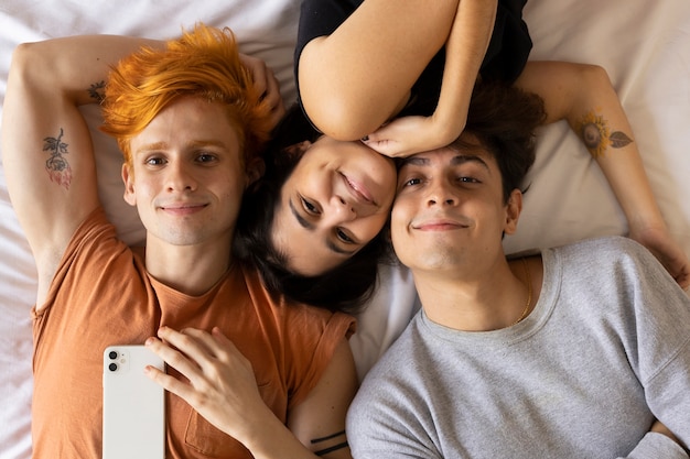 Socios laicos planos tomando selfie en la cama