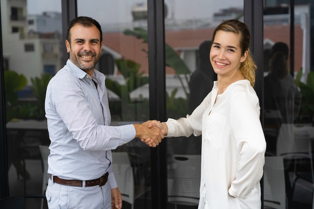 Socios de negocios positivos dándose la mano